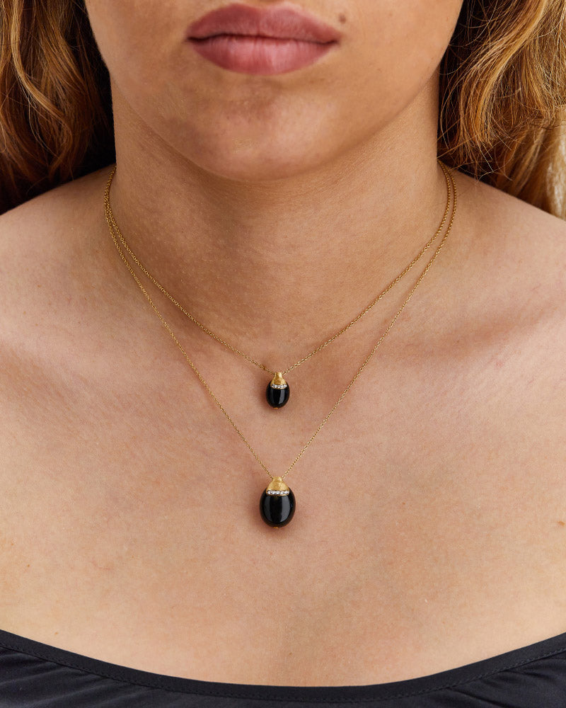 "Mystery Black" Black Onyx boule embraced by Gold and a diamonds accent